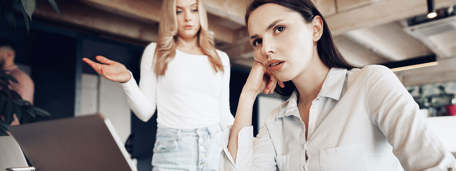 a woman is annoyed and trying to ignore her coworker