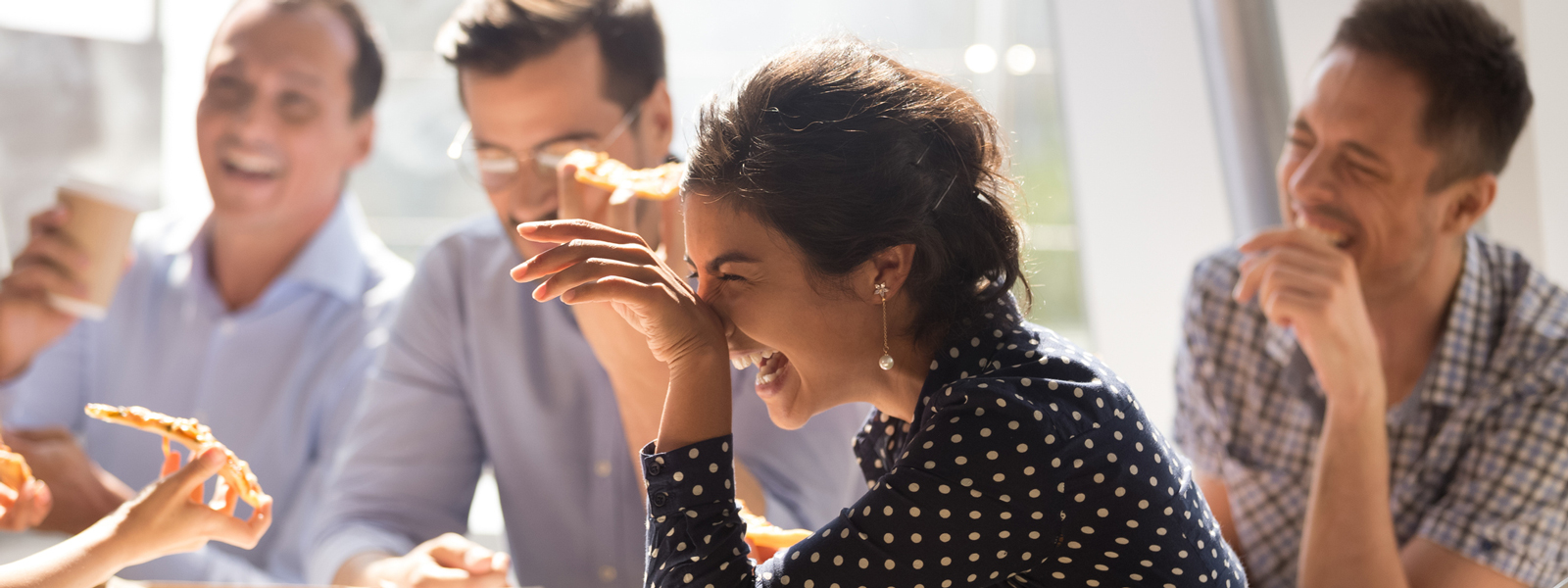 coworkers laughing together over pizza