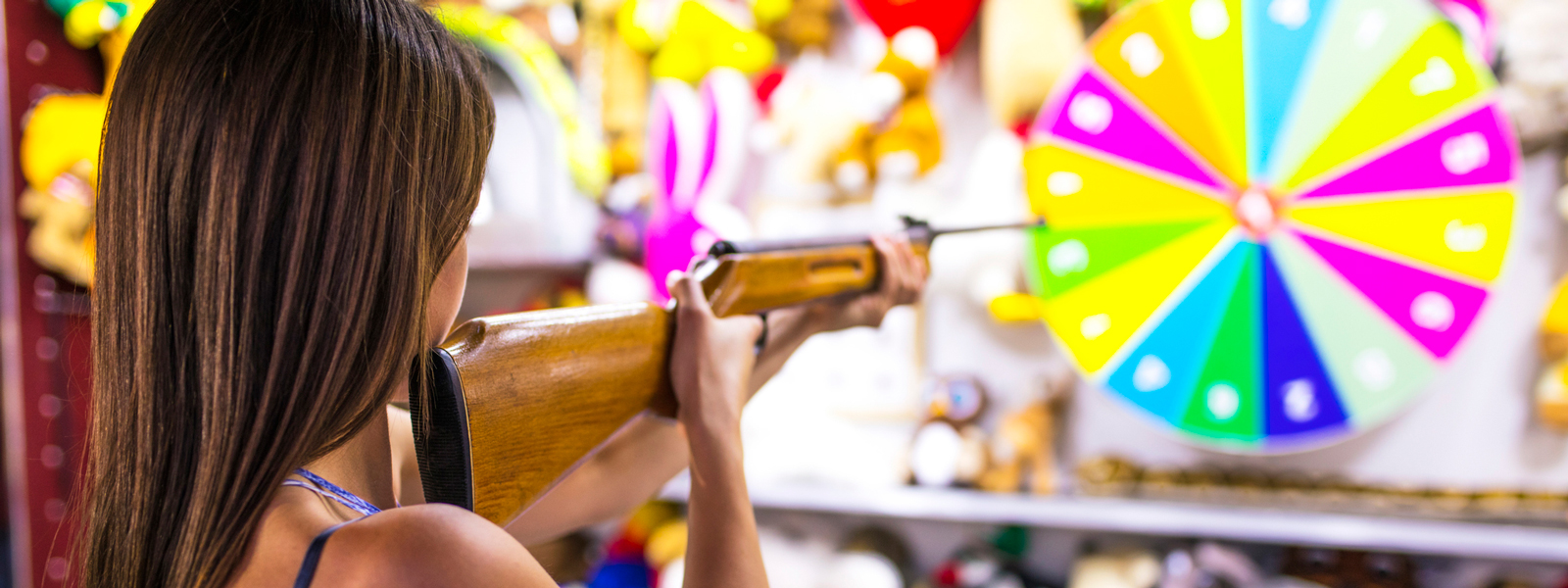 a woman aiming for a target in a carnival game