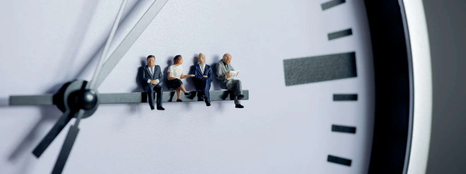 A photo of a team sitting on the hands of a ticking clock